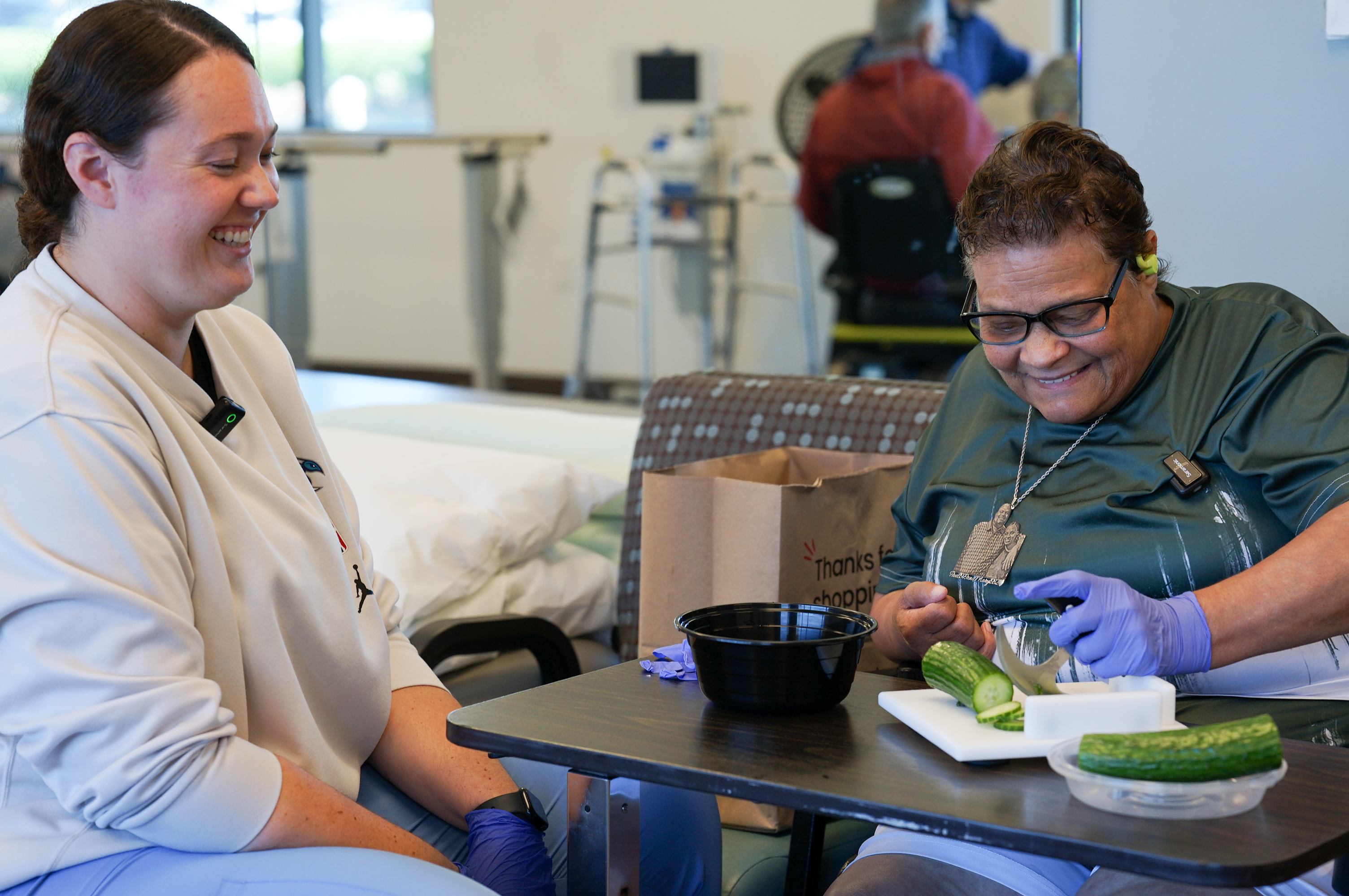 Deborah Jackson cuts a cucumber with the assistance of PACE staff