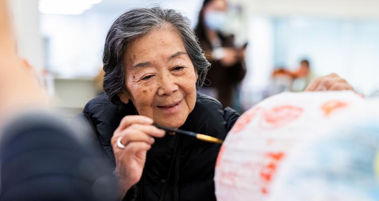 Senior Woman Painting a Paper Lantern