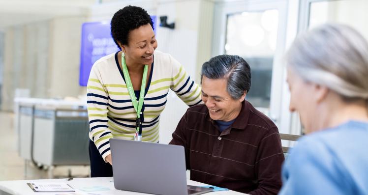 Someone helping a senior on a laptop computer