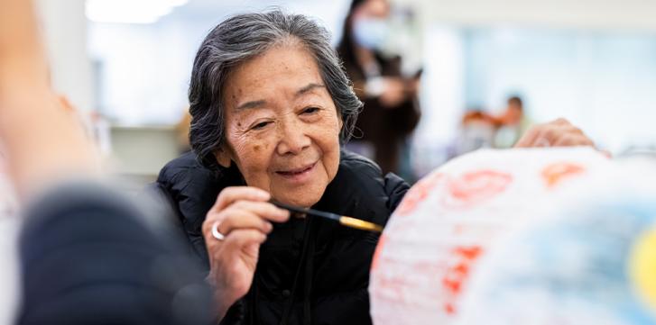 Senior Woman Painting a Paper Lantern