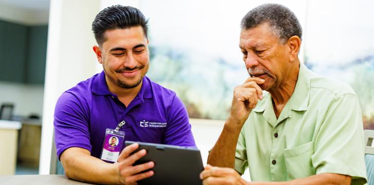 Caregiver Showing a Tablet to a Elder Senior