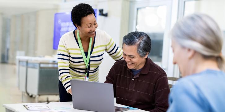 Someone helping a senior on a laptop computer