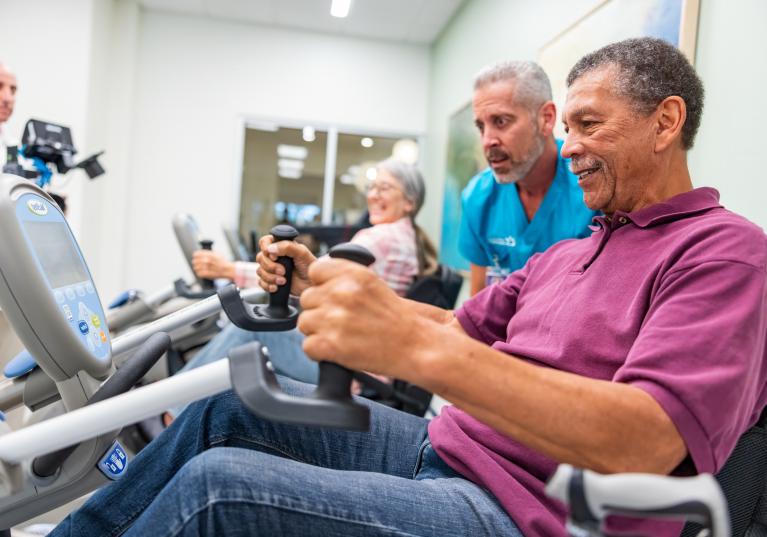 Senior man performing physical therapy exercises with a trainer