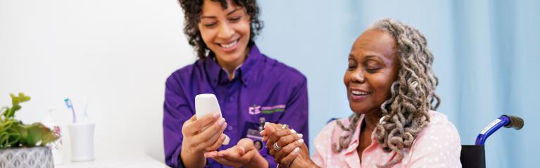 Elderly Woman with Caregiver Helping with Hand Sanitizer