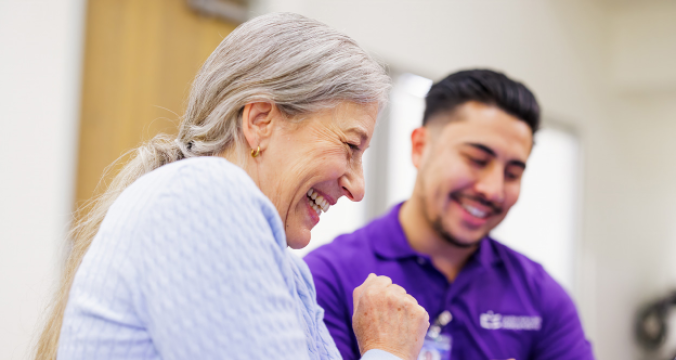 Elderly Participant with a Caregiver Smiling