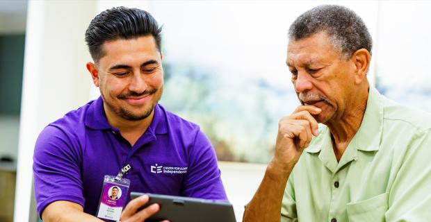 Caregiver and Elder Looking at Tablet