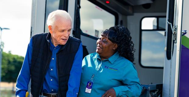 Caregiver Helping Man off the Bus